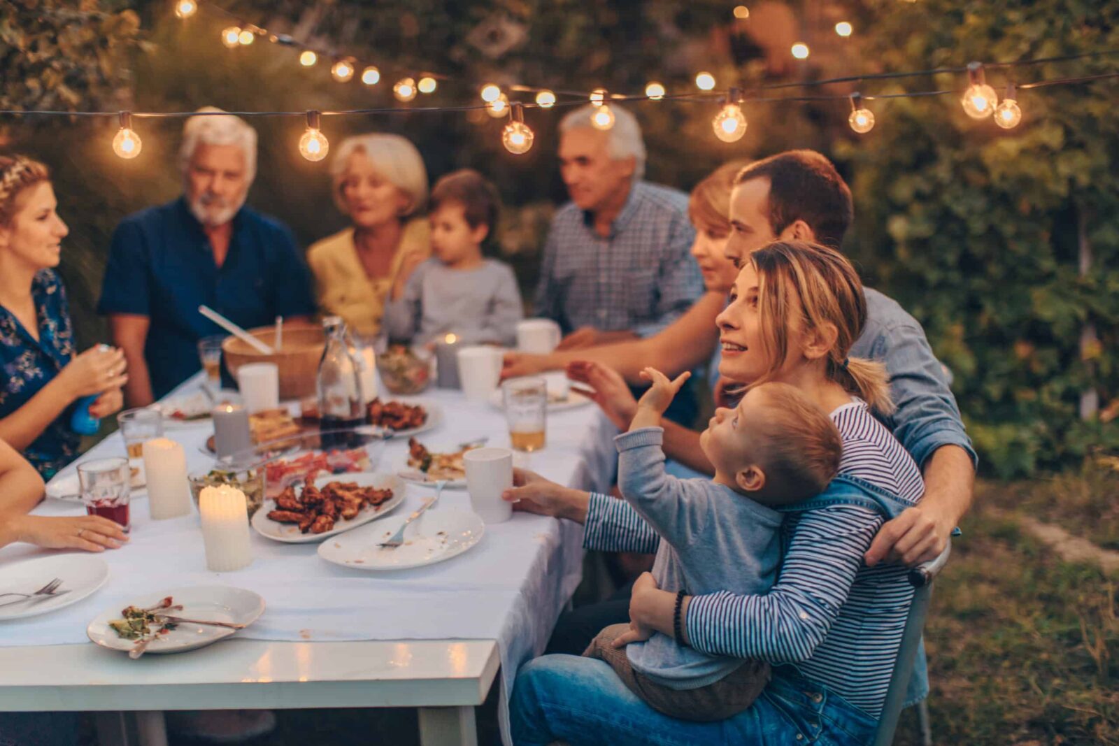 Foto di una grande famiglia durante la cena di Ringraziamento, celebrando le vacanze insieme nel cortile sul retro